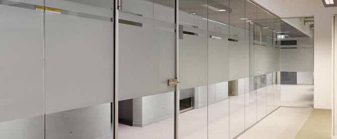 Hard glazen deur in systeemwand van glas